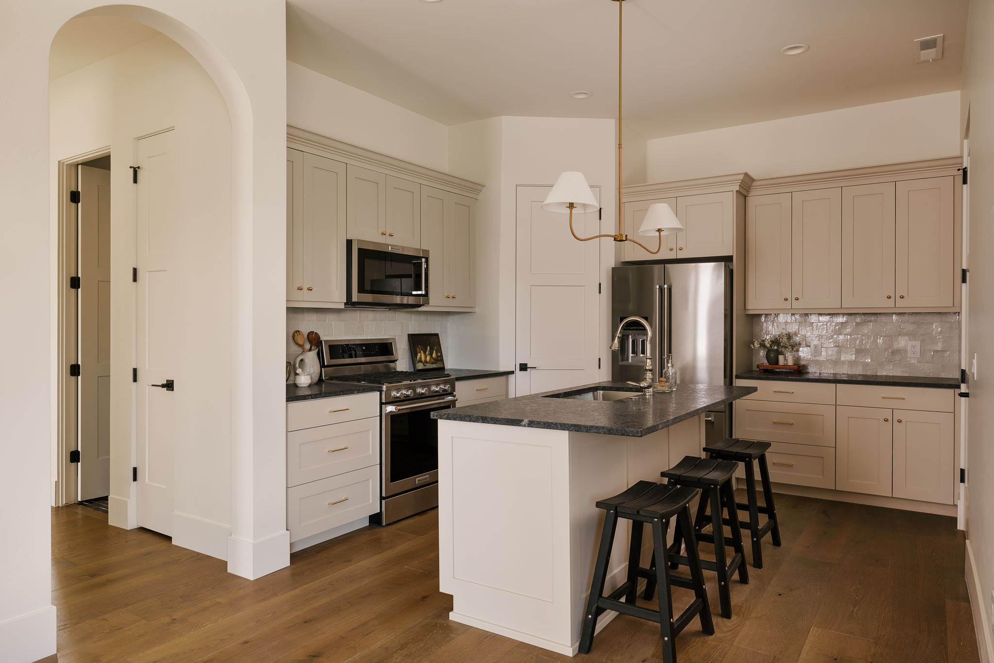 Casita Kitchen featuring stainless steel appliances, a center island with sink, dark wood finished floors, Leathered granite countertops and a breakfast bar