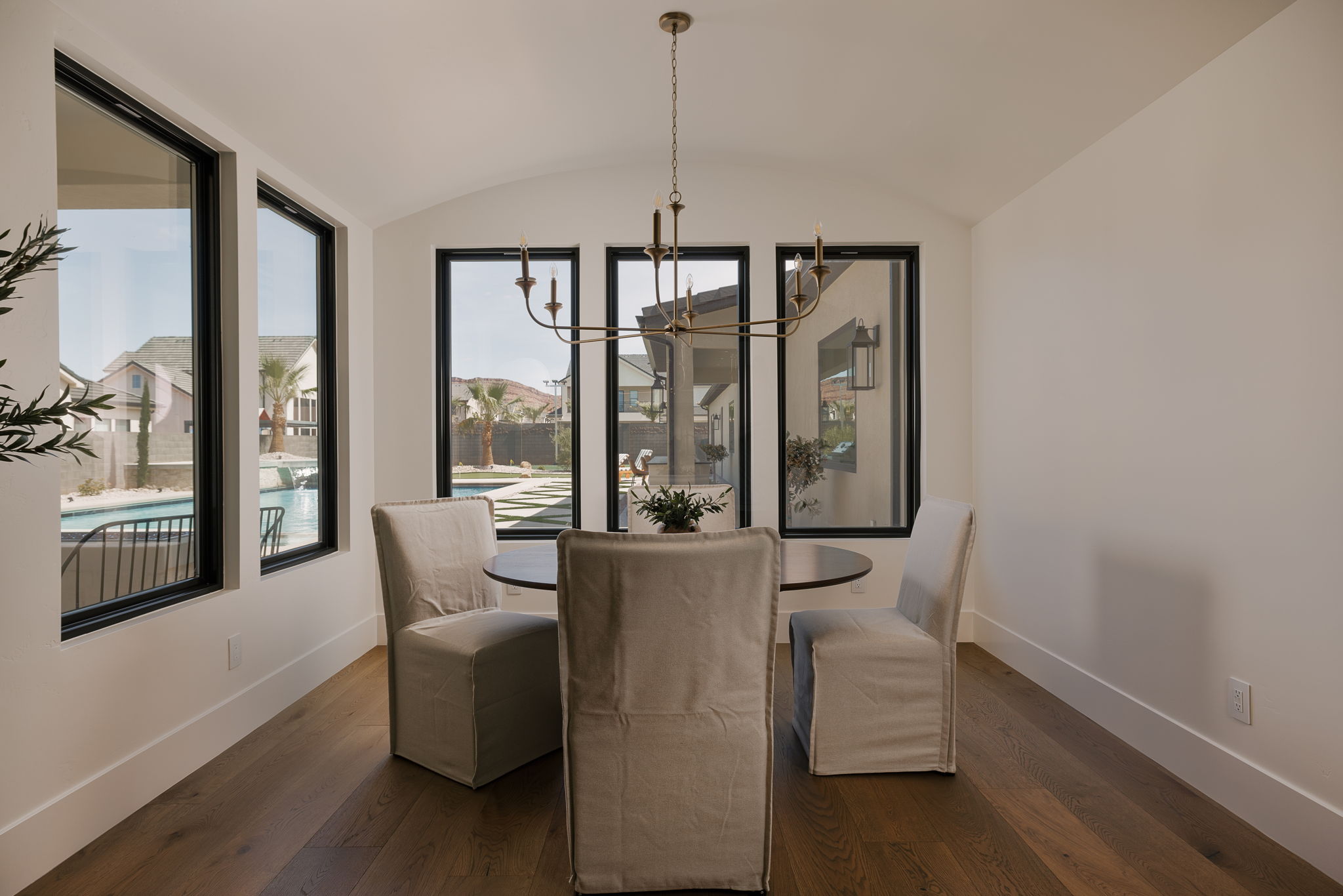 Dining space featuring suspended lighting, wood-type flooring, a barrel ceiling, and healthy amount of natural light