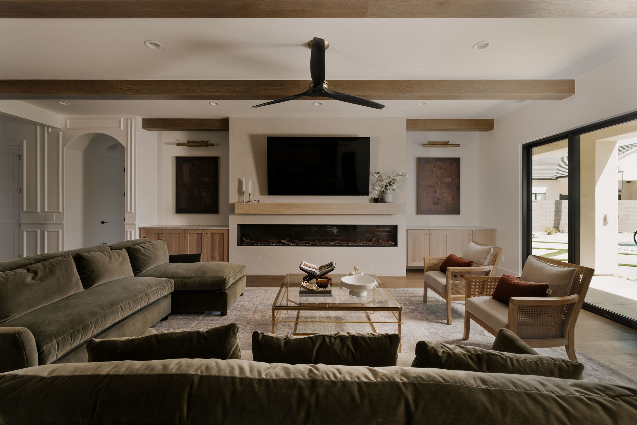 Living room featuring recessed lighting, a glass covered fireplace, a ceiling fan, wood finished floors, and arched walkways