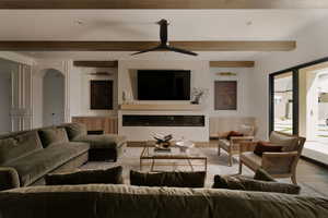 Living room featuring recessed lighting, a glass covered fireplace, a ceiling fan, wood finished floors, and arched walkways
