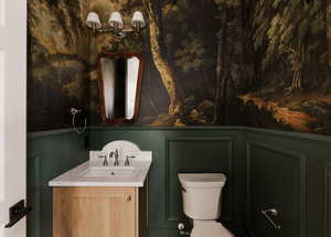 Powder Bathroom featuring vanity and a decorative wall