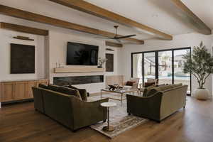 Living room with a glass covered fireplace, ceiling fan, beam ceiling, dark wood finished floors, and recessed lighting