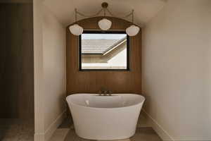 Primary bath featuring a freestanding tub and wood finished floors