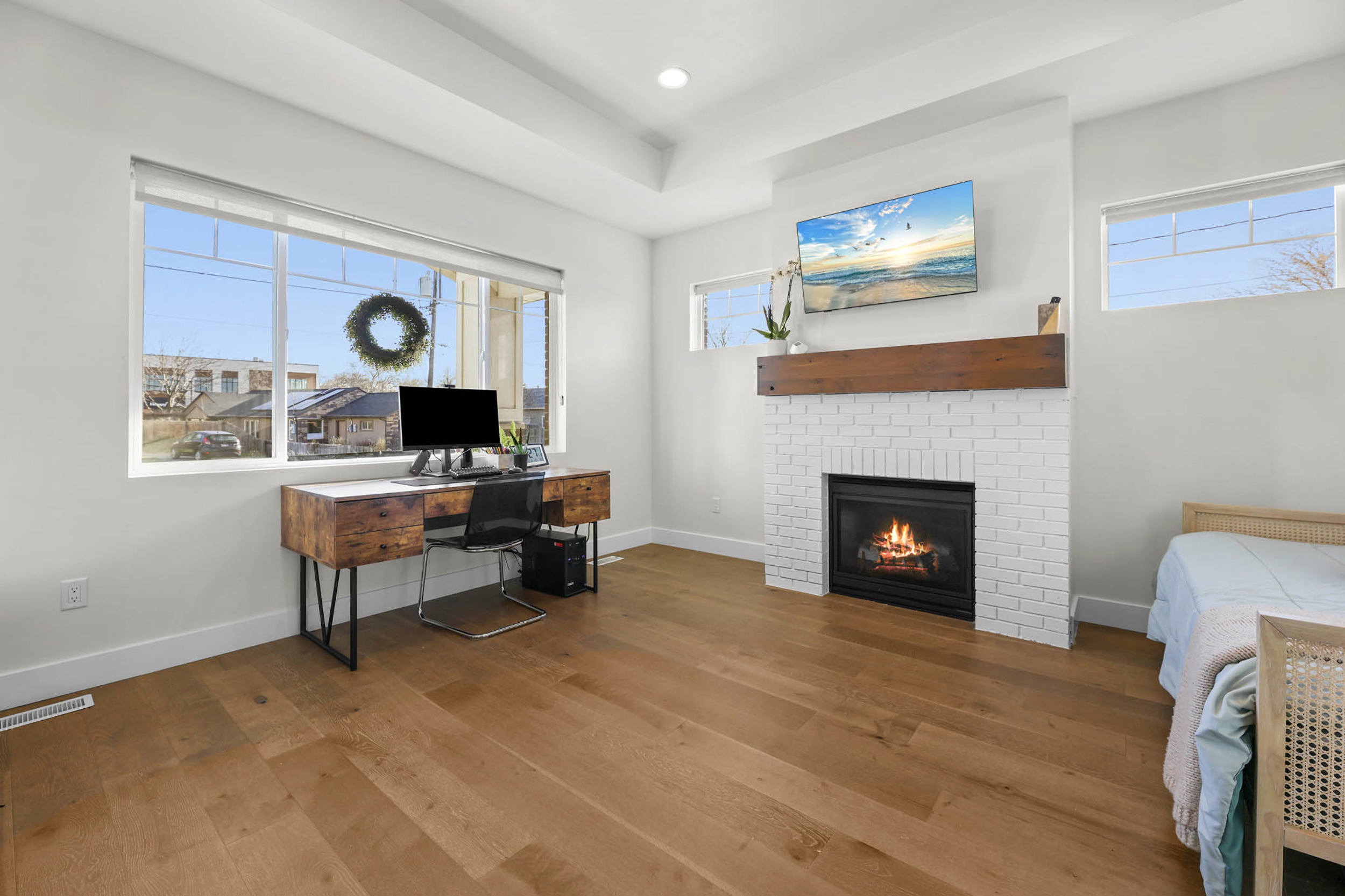 Office area with wood-type flooring, a brick fireplace, healthy amount of natural light, and recessed lighting