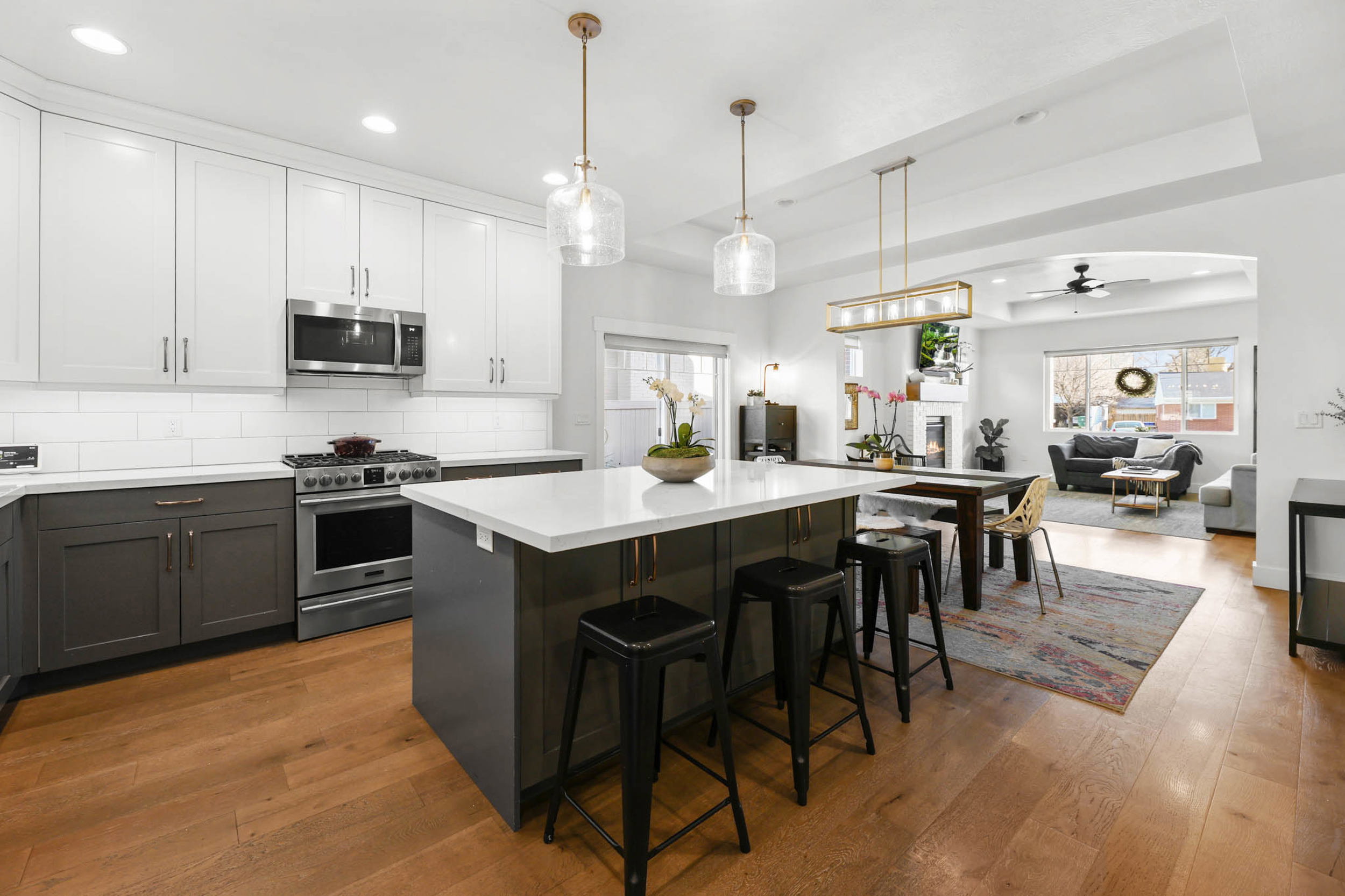 Dual tone kitchen featuring two tone color scheme, a kitchen bar, stainless steel appliances, a center island, and open floor plan