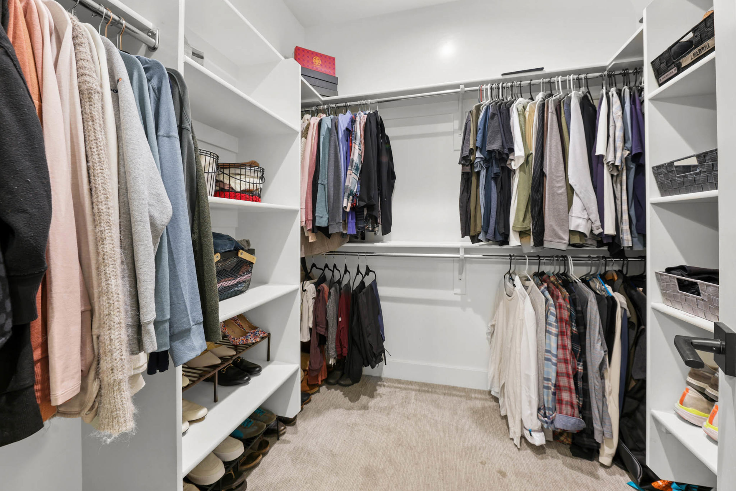 Walk in closet with light colored carpet