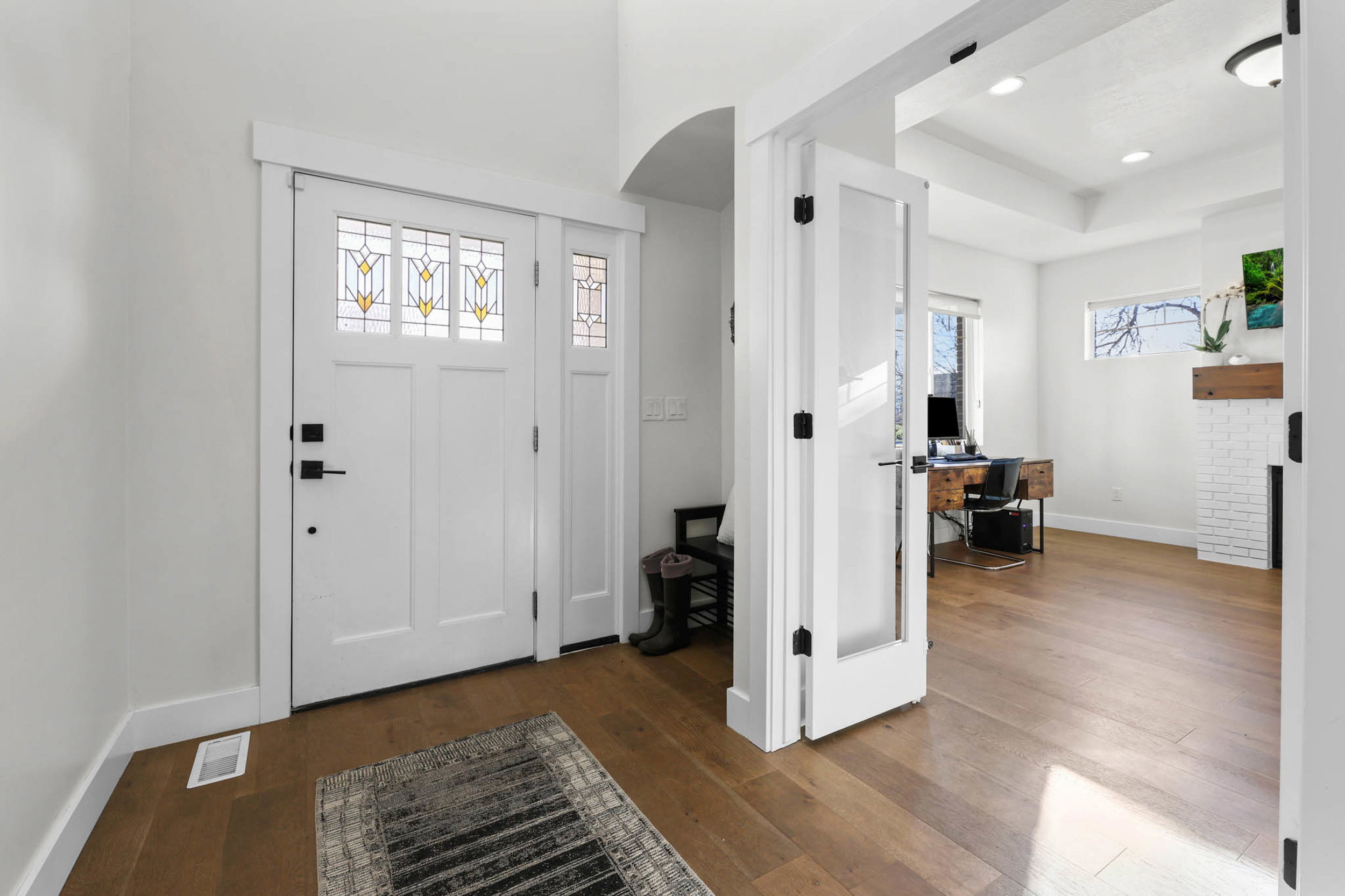 Entryway featuring dark wood-type flooring, a raised ceiling, and recessed lighting