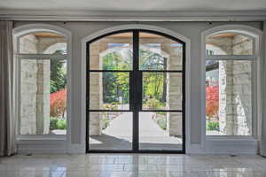 Entryway with french doors and marble tile flooring - bringing the outside in.