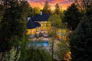Back of house with a spa, pool, huge .91ac yard, decks and patios, in ground trampoline, basketball court and more!