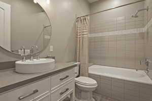 Bathroom featuring vanity, tiled shower / bath, and light wood-style flooring