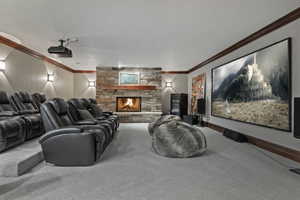 Beautiful home theater room featuring a fireplace, wet bar with tons of cabinetry and room for a crowd