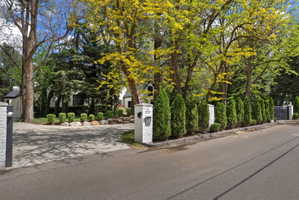 View of front facade, gates and treelined street