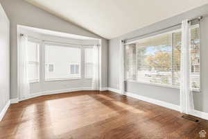 Empty room featuring vaulted ceiling and light wood finished floors