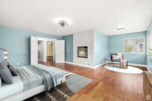 Bedroom featuring hardwood / wood-style floors and a brick fireplace