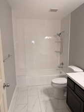 Bathroom with vanity, light marble finish floors, and washtub / shower combination