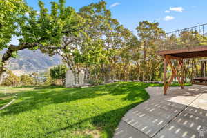 View of grassy yard featuring a shed and a mountain view