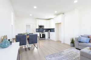 Living area featuring light wood-style flooring and recessed lighting