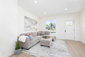 Living area featuring light wood-style flooring and recessed lighting