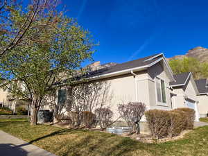 View of property exterior featuring stucco siding, a yard, and an attached garage