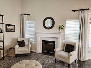 Sitting room featuring a fireplace with flush hearth and dark wood-style flooring