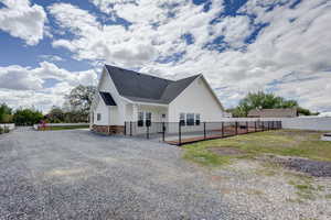 View of side of property featuring a fenced patio area with firepit.
