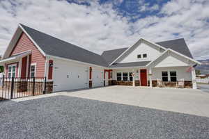 Craftsman-style house with a shingled roof, concrete driveway, stone siding, and a garage