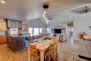Dining room with dark wood-type flooring, a chandelier, and a high textured ceiling