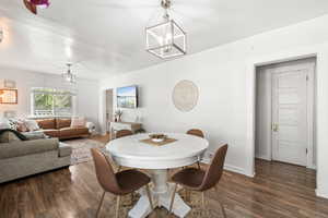 Dining area with dark wood-type flooring and suspended lighting