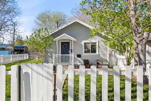 View of front of property featuring a fenced front yard and a gate