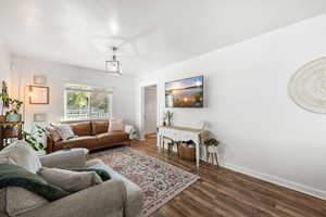 Living area with dark wood-style floors and baseboards