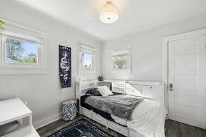 Bedroom with baseboards and dark wood-type flooring