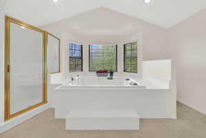 Bathroom with a shower stall, a garden tub, and light tile patterned floors