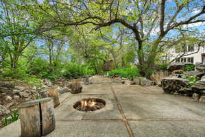 Downstream view of backyard patio / terrace with an outdoor fire pit