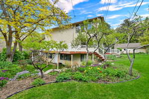 Back of property with a wooden deck and a yard