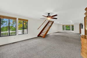 Unfurnished living room with a ceiling fan and carpet