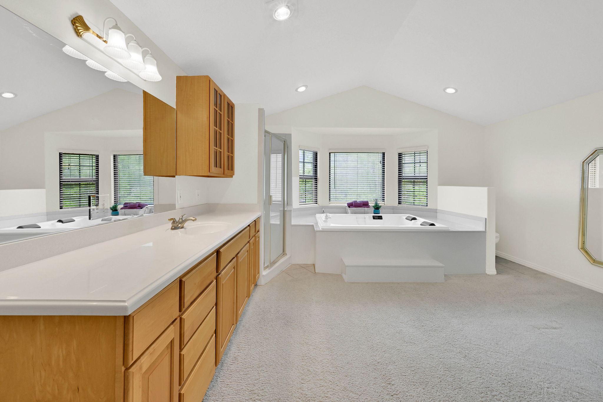 Full bathroom with a bath, a shower stall, vanity, light colored carpet, and recessed lighting