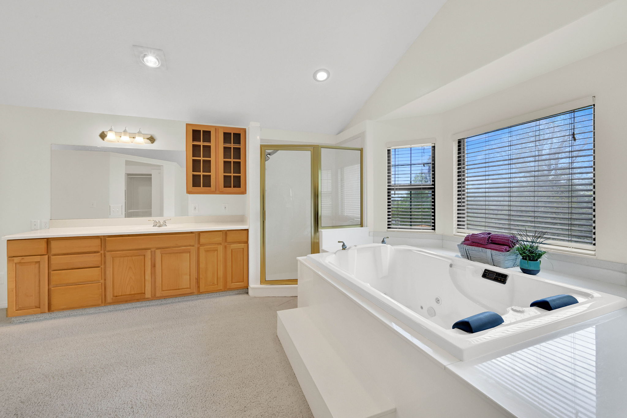 Full bath with vaulted ceiling, vanity, a shower stall, a jetted tub, and recessed lighting