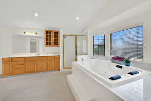 Full bath with vaulted ceiling, vanity, a shower stall, a jetted tub, and recessed lighting