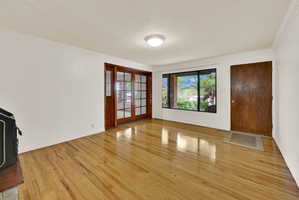 Foyer featuring light wood-style flooring, ornamental molding, and a textured ceiling