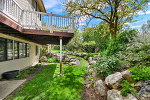 View of green lawn featuring a wooden deck