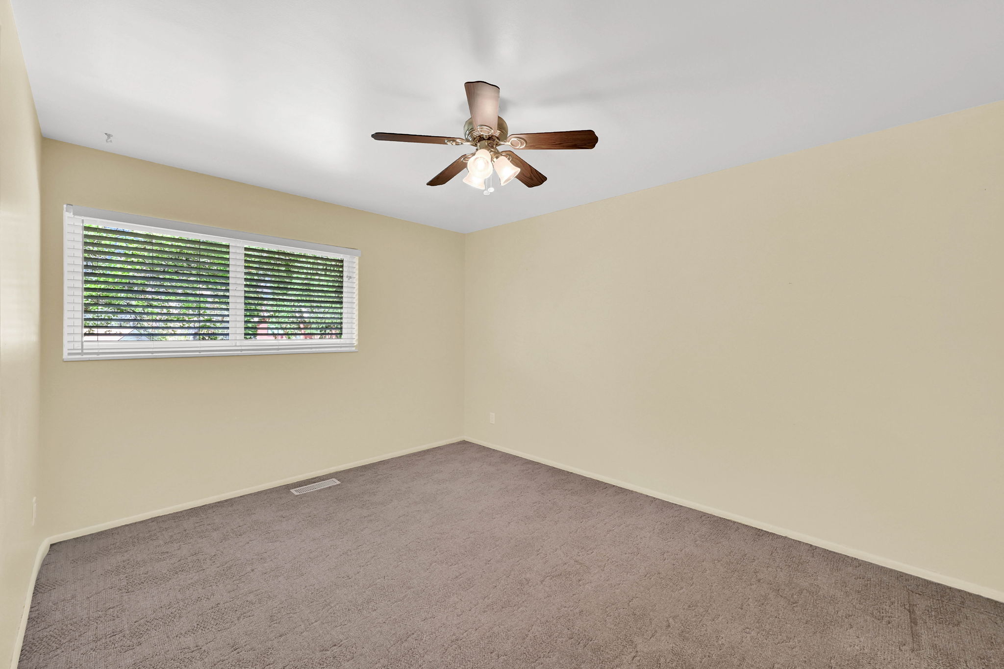 Spare room with dark colored carpet and a ceiling fan