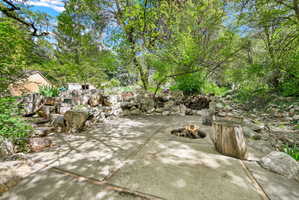 View of patio / terrace featuring view of stream and firepit