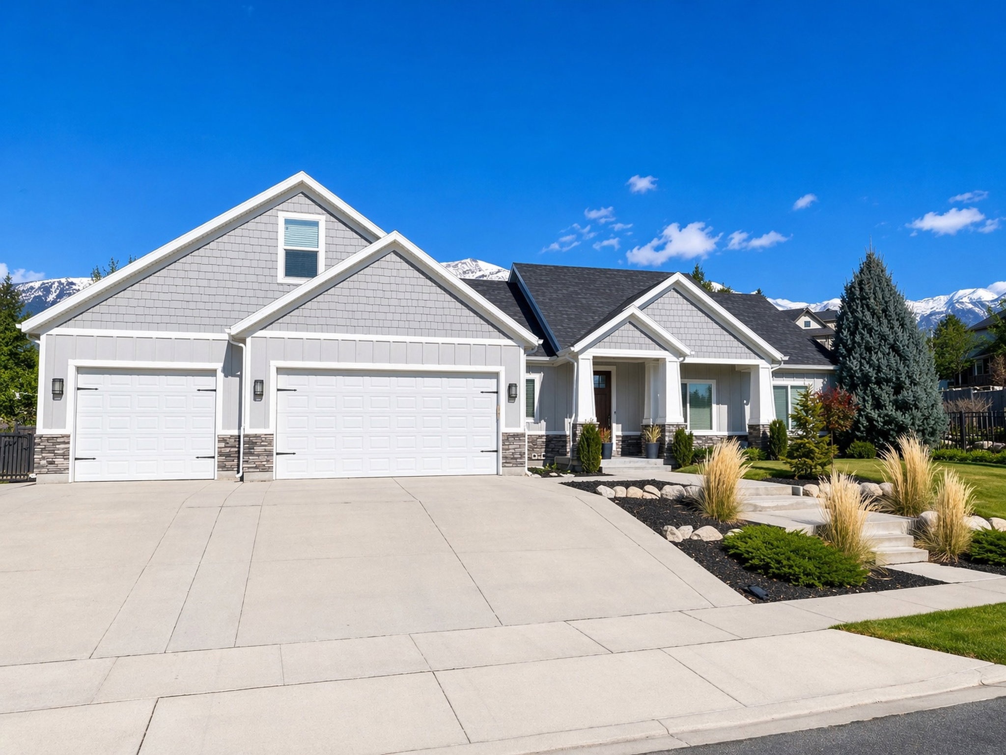 Craftsman-style house featuring board and batten siding, an attached garage, concrete driveway, and stone siding