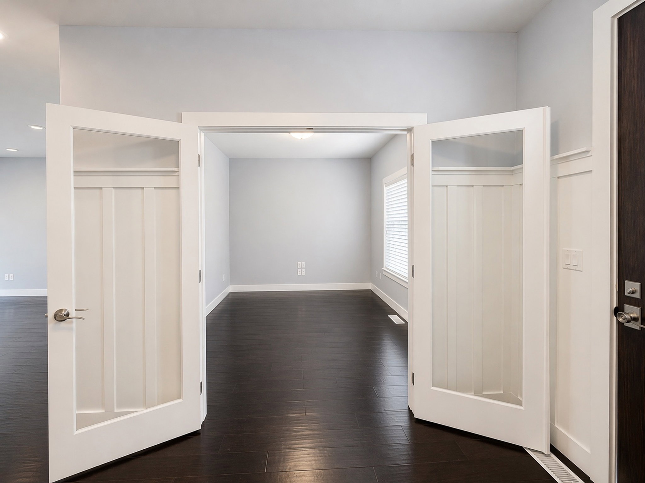 Unfurnished bedroom with dark wood-style flooring and baseboards