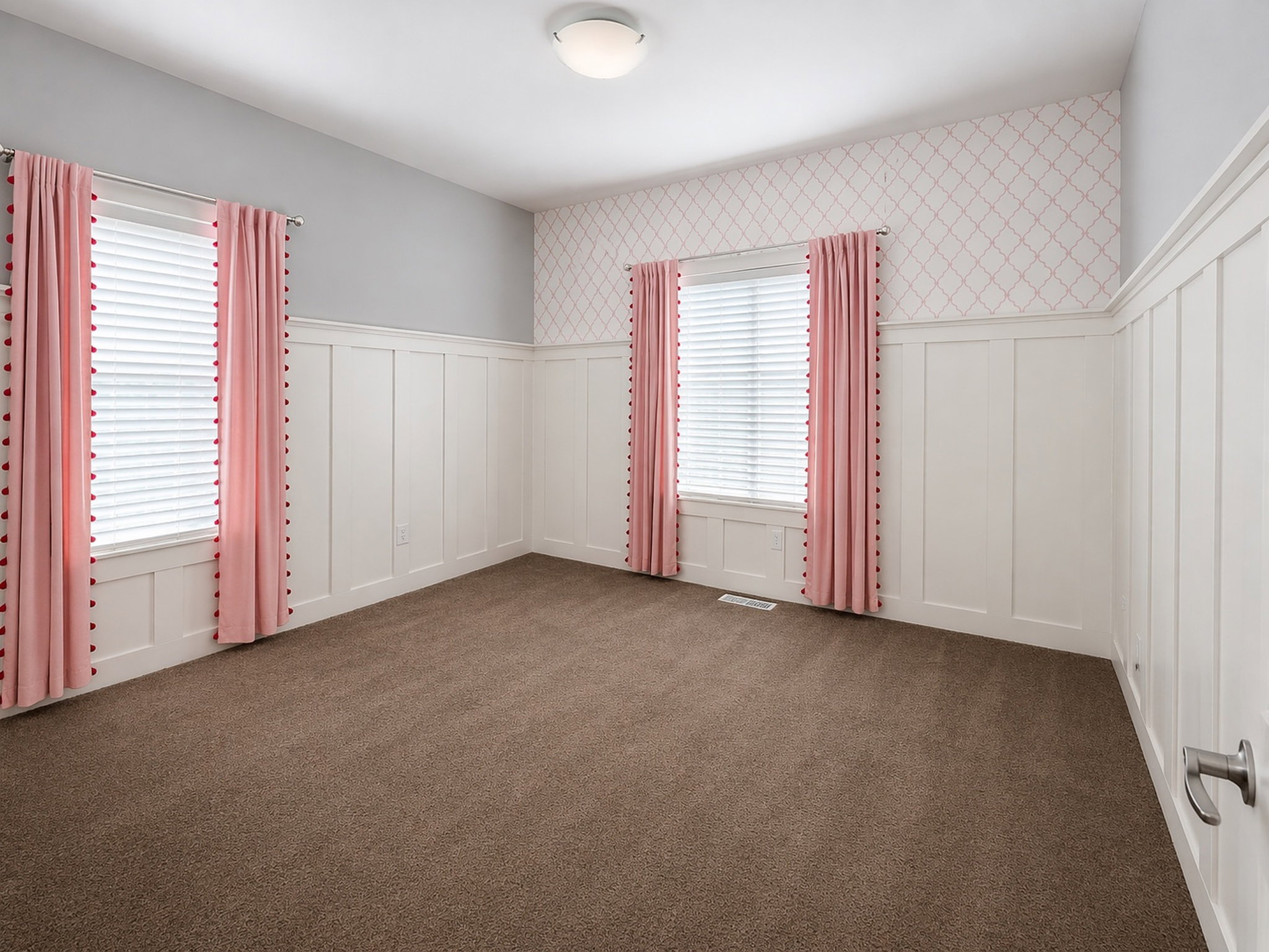 Unfurnished room featuring wainscoting, a decorative wall, and dark colored carpet