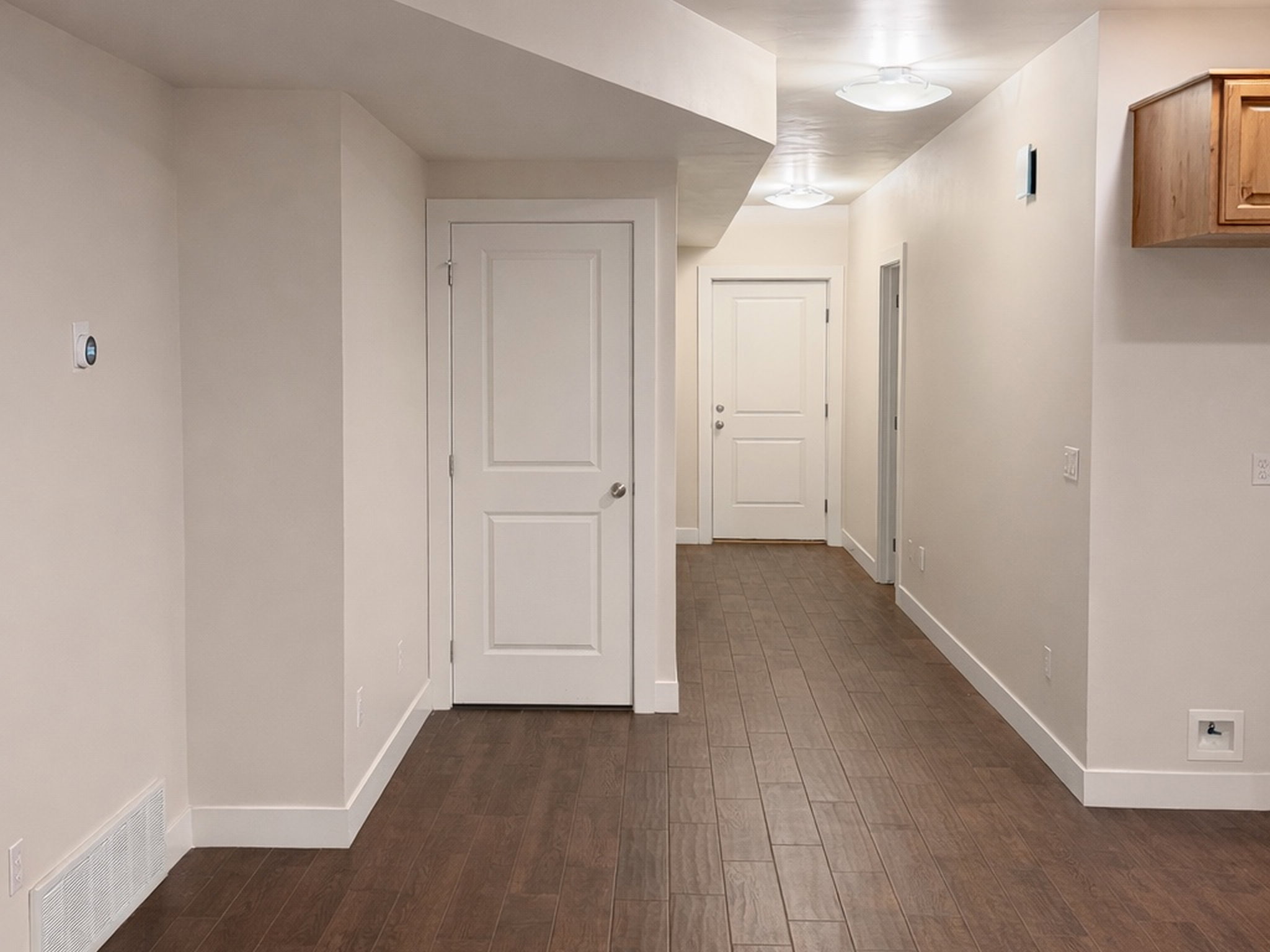 Hall featuring baseboards and dark wood-style flooring