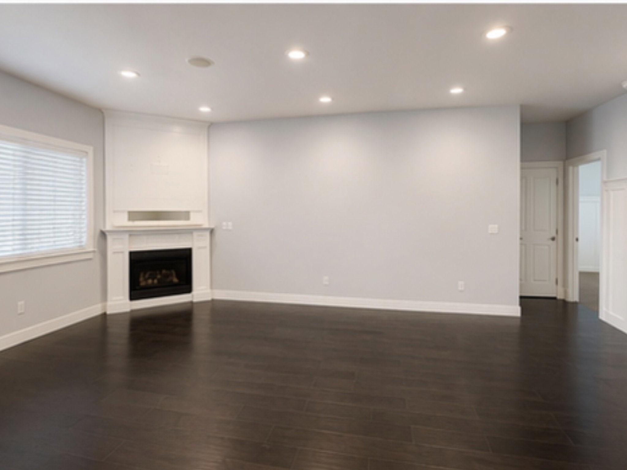 Unfurnished living room with recessed lighting, a fireplace, and dark wood finished floors