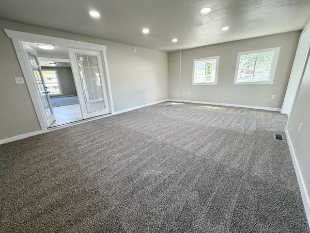 Family room with entrance to kitchen and an exterior entrance to the back yard.