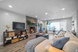 Living area with wood finished floors, a fireplace, and recessed lighting