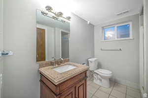 Full bath with vanity, light tile patterned floors, and a shower